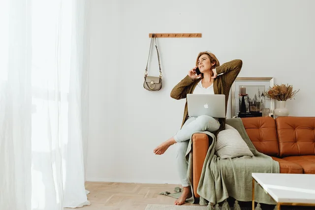 woman, indoors, laptop, macbook, computer, on the phone, young woman, sofa, living room, living room, living room, living room, living room, living room. How to find women entrepreneur grants in the UK